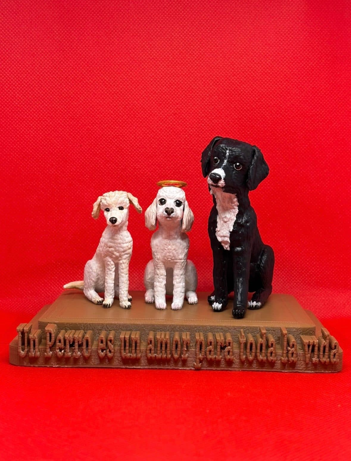 Retrato escultórico de tres perros pintados a mano, reunidos sobre una base de madera.