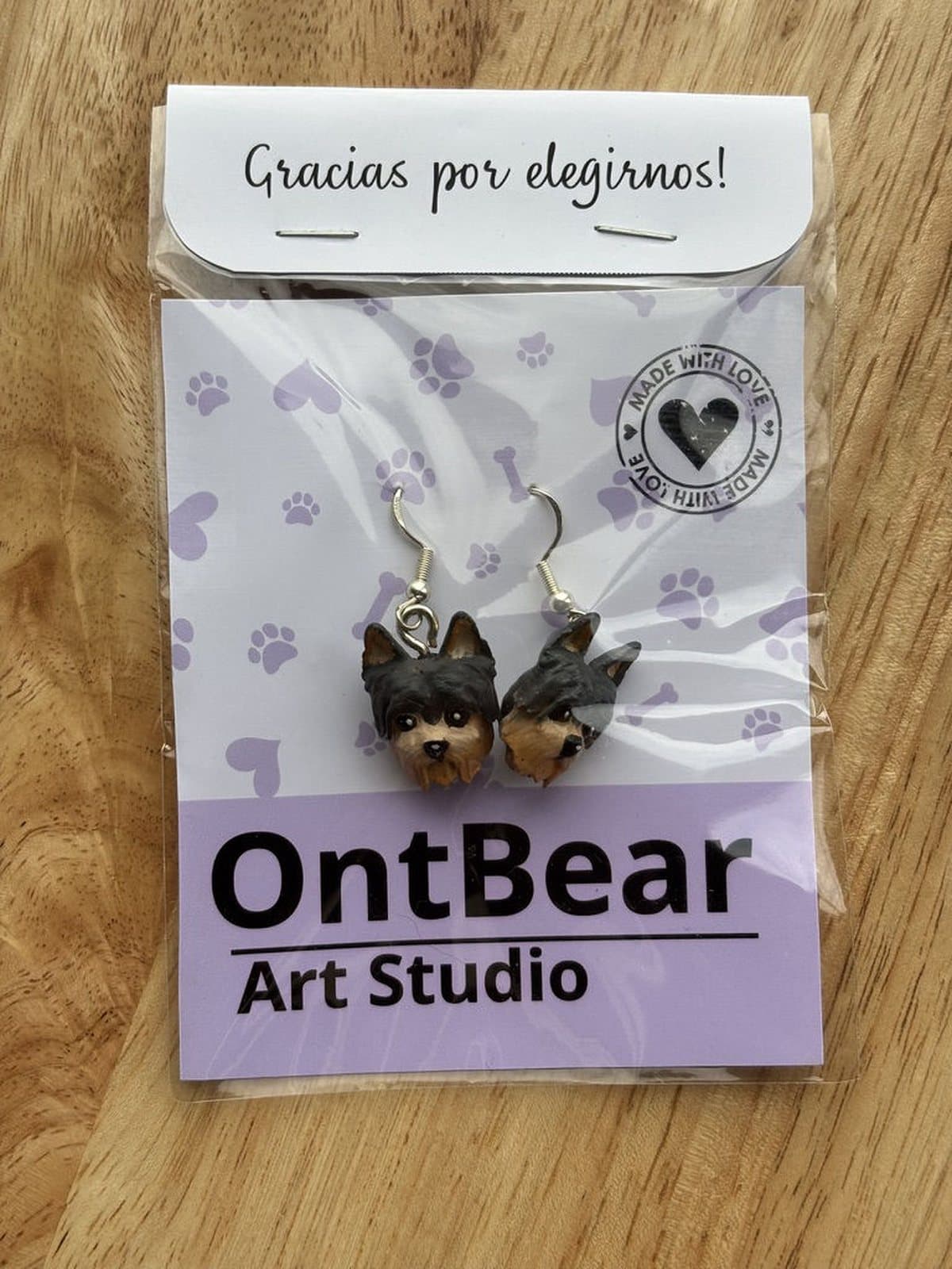 Par de aretes pintados a mano con caritas de yorkshire, en su empaque de OntBear.
