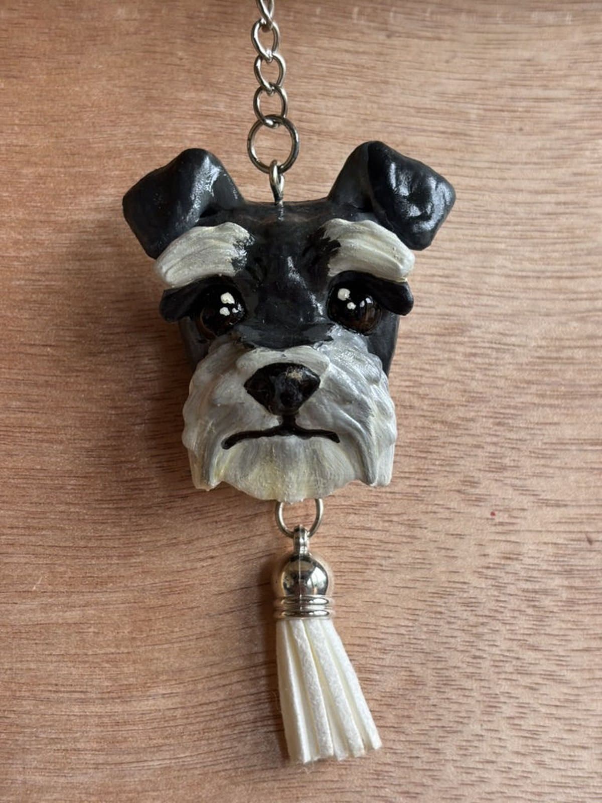 Llavero pintado a mano de un schnauzer blanco y negro, con borla blanca.